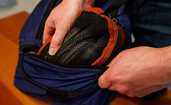 A person inserting a Small Snake Charmer into the bottom pocket of a Synapse 19.